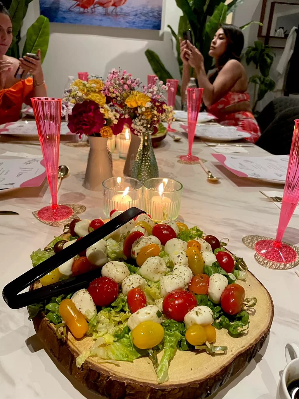 Caprese salad with fresh mozzarella and heirloom tomatoes on a rustic wood round